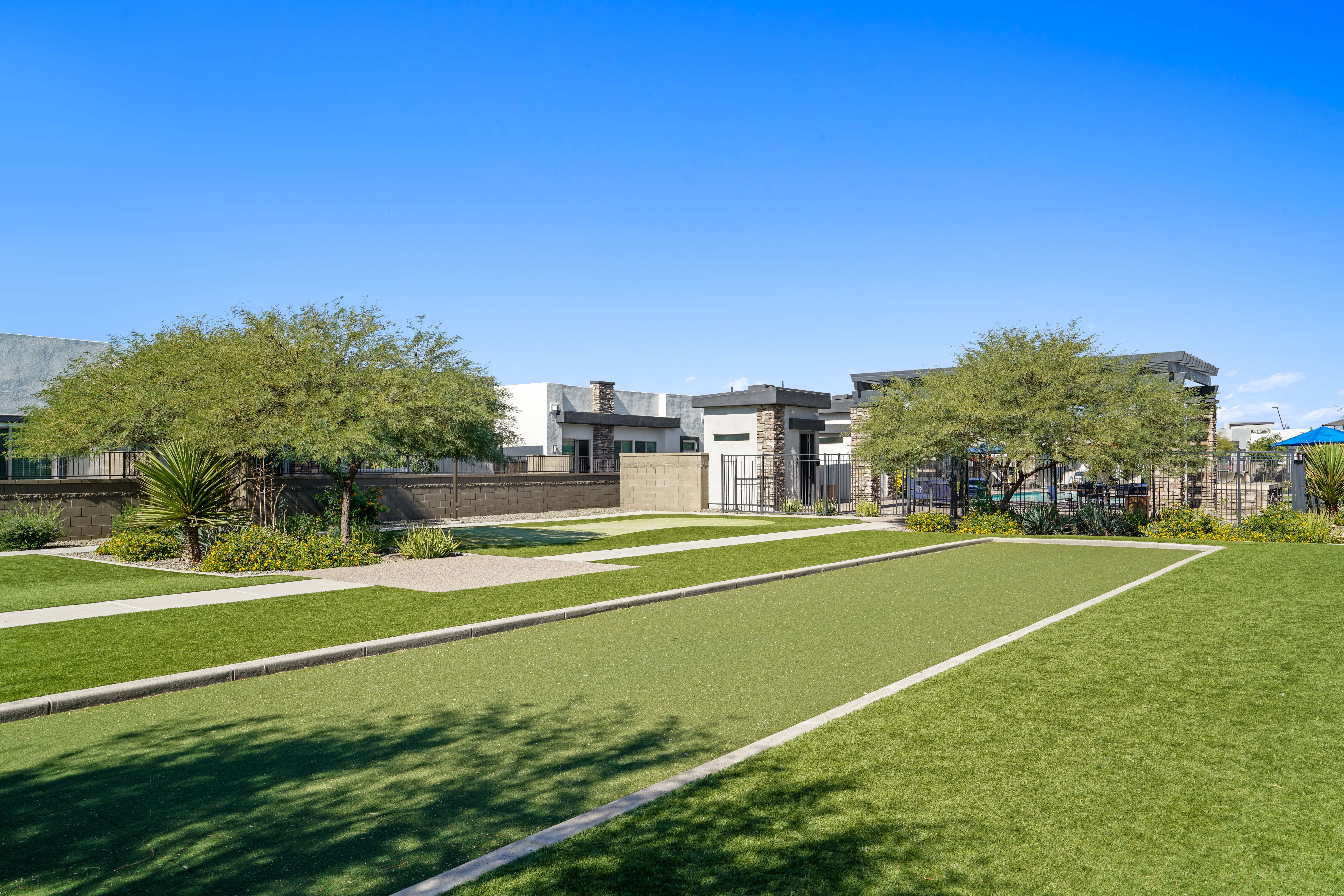 a park with grass and trees and buildings in the background at Olive Queen Creek Apartments, Queen Creek, Arizona